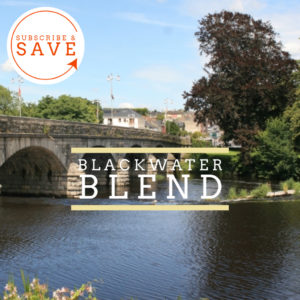 Badger and Dodo Coffee Roasters: A picturesque river view with a stone bridge and lush greenery stretches beneath Blackwater Blend. In the top left, a circular badge saying Subscribe & Save is accompanied by an arrow, drawing your attention to this tempting offer.