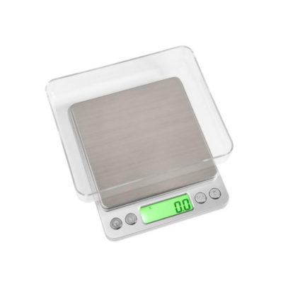 Badger and Dodo Coffee Roasters: Introducing the Envy Series Miniscale 3000g: a sleek kitchen scale with a stainless steel surface, green backlit display at zero, and clear cover. It features three intuitive buttons and handles up to 3000g precisely.