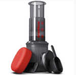 Badger & Dodo. Aeropress Go Travel Kit with red travel case, scoop, and stirrer, all accessories neatly arranged on a white background.