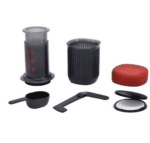 Badger & Dodo. The Aeropress Go Travel Kit, shown on a white background, includes a plunger, cup, filter holder, scoop, stirrer, and red lid—everything needed for a compact travel coffee maker.