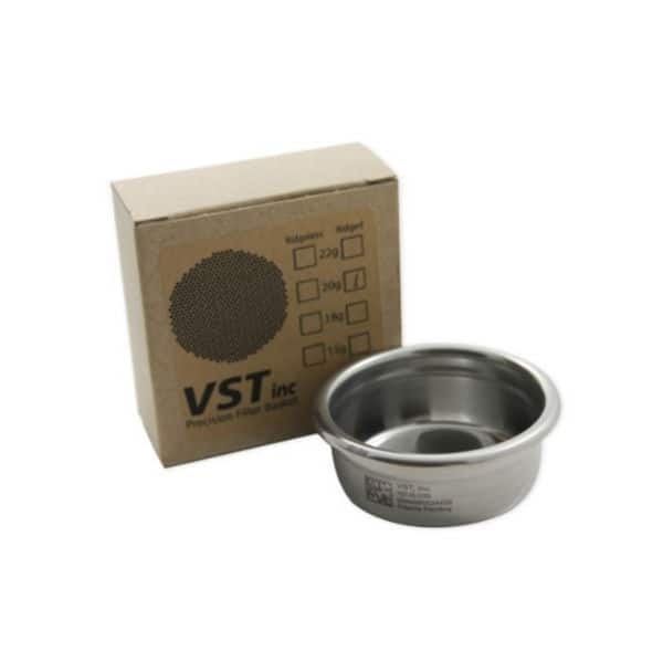 Badger and Dodo Coffee Roasters: A sleek metal filter basket, perfect for coffee accessories enthusiasts, sits beside a brown cardboard box adorned with black text and checkboxes indicating weights up to 20g. The box proudly features the VST inc logo in elegant black font.