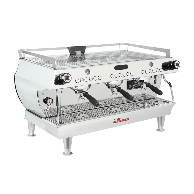 Badger and Dodo Coffee Roasters: The La Marzocco GB5 is a stainless steel commercial espresso machine boasting three group heads and portafilters. Its sleek, modern design features knobs and dials on the front panel, while sturdy legs provide elevation and stability.