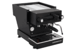 Badger & Dodo. The La Marzocco Linea Mini - Nera is a black espresso machine with silver accents and a steam wand, shown from the front-left angle.