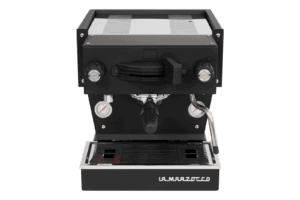 Badger & Dodo. Front view of a sleek La Marzocco Linea Mini - Nera, black and silver espresso machine on a gray background.