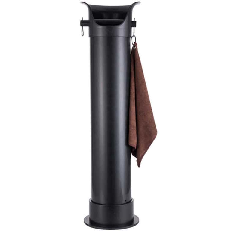 Badger and Dodo Coffee Roasters: A tall, black golf ball washer with a brown towel hanging on its side resembles a sleek knock box. The cylindrical design features a chute-like compartment at the top for cleaning golf balls, typically found on golf courses for players convenience.