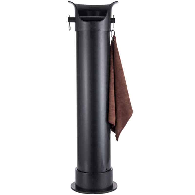 Badger and Dodo Coffee Roasters: A tall, black golf ball washer with a brown towel hanging on its side resembles a sleek knock box. The cylindrical design features a chute-like compartment at the top for cleaning golf balls, typically found on golf courses for players convenience.