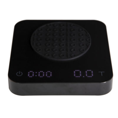 Badger and Dodo Coffee Roasters: The Acaia Pearl S - Black kitchen scale includes a digital display with 0:00 on the left and 0.0T on the right, perfect for coffee lovers. Its round, textured weighing surface and bottom-left power button ensure precision brewing is simple and effective.