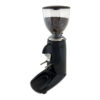Badger and Dodo Coffee Roasters: The Compak K3 Touch, a stylish black grinder, has a clear hopper filled with beans and features a handy dispensing chute. It sits on a black base with an integrated tray for grounds, all elegantly placed on a clean white surface.