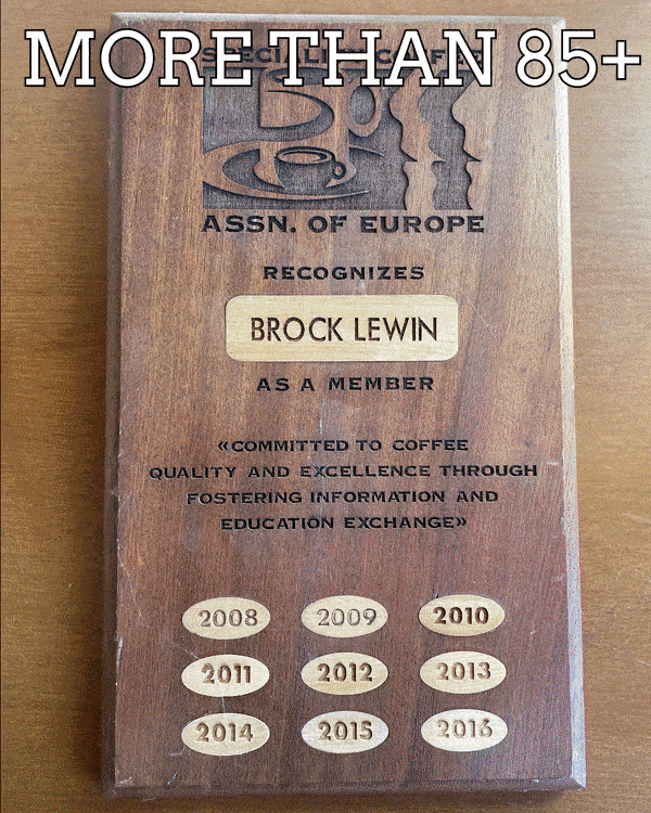 Badger and Dodo Coffee Roasters: A wooden plaque adorned with coffee cup symbols proudly reads More Than 85+, honoring Brock Lewin for coffee quality excellence from 2008-2016. The engraved text emphasizes a steadfast commitment to information and education exchange.