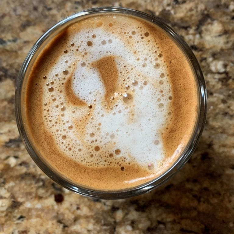 Badger and Dodo Coffee Roasters: A birds-eye view of a cappuccino with frothy milk art on top, set against a textured brown stone surface.