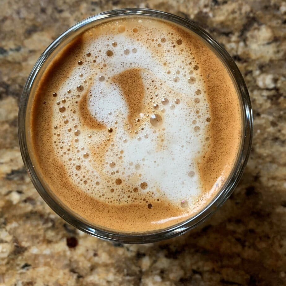 Badger and Dodo Coffee Roasters: A birds-eye view of a cappuccino with frothy milk art on top, set against a textured brown stone surface.