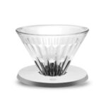 Badger & Dodo. The Timemore Filter V01 Glass - Crystal Eye features a clear, ridged cone on a white round flat holder, designed to fit easily on a scale, shown against a white background.