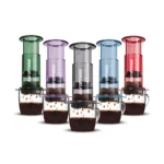 Badger & Dodo. Five Aeropress Coffee Maker-Clear Colours brew rich coffee into clear mugs, each pouring out vibrant coffee drops in a range of clear hues.