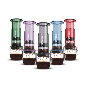 Badger & Dodo. Five Aeropress Coffee Maker-Clear Colours brew rich coffee into clear mugs, each pouring out vibrant coffee drops in a range of clear hues.