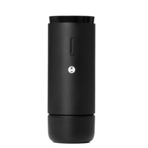 A tall, cylindrical black travel mug with a matte finish and a small hourglass-shaped button on the front.